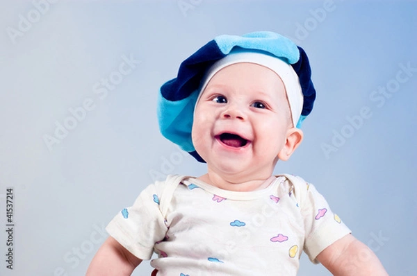 Obraz Amusing baby boy in a beret in a studio on a dark blue backgroun