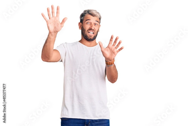 Obraz Young handsome blond man wearing casual t-shirt smiling with hands on chest with closed eyes and grateful gesture on face. health concept.