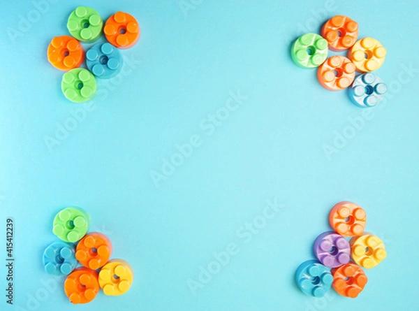 Fototapeta  Plastic building blocks isolated on blue background. Top view with copy space