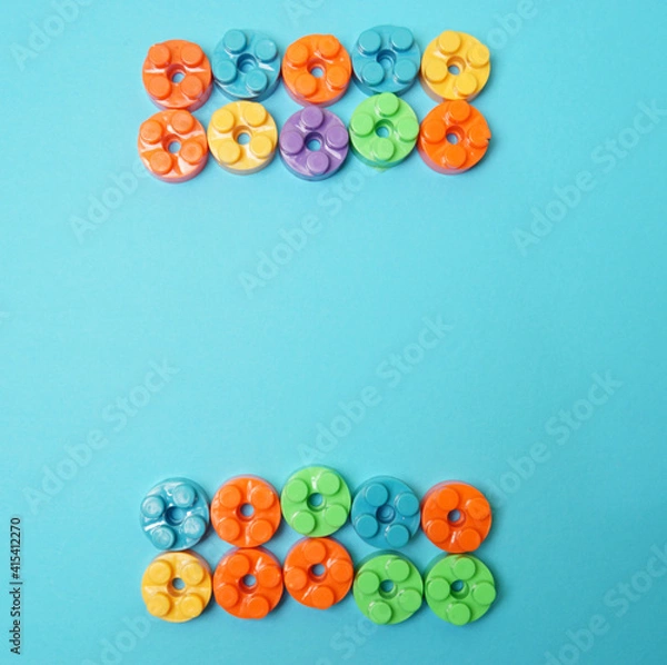 Fototapeta Plastic building blocks isolated on blue background. Top view with copy space