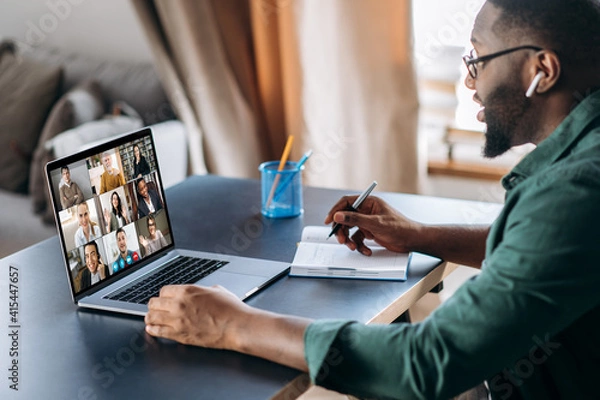 Obraz Online business briefing. Male African American employee speak on video call with diverse multiracial colleagues, on laptop screen diverse business people, meeting online, group brainstorm