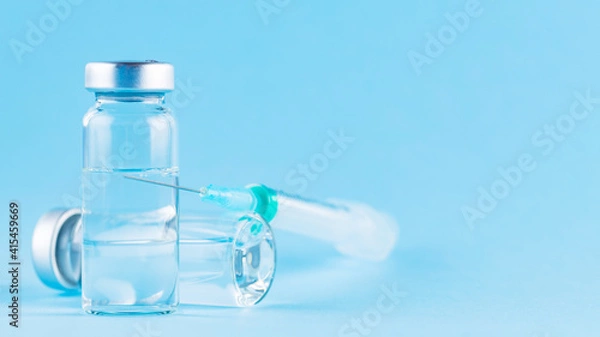 Fototapeta Vaccine and syringe injection. Vaccines and syringe on a blue background for prevention and immunization. Vaccine and healthcare medical concept. Copy space