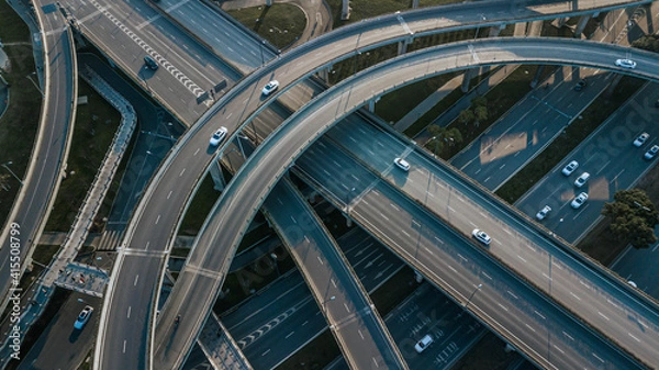 Fototapeta Top up aerial drone view of elevated road and traffic junctions in Chinese metropolis city Chengdu during sunny day. Modern construction design of traffic ways to avoid traffic jams. Few vehicles.