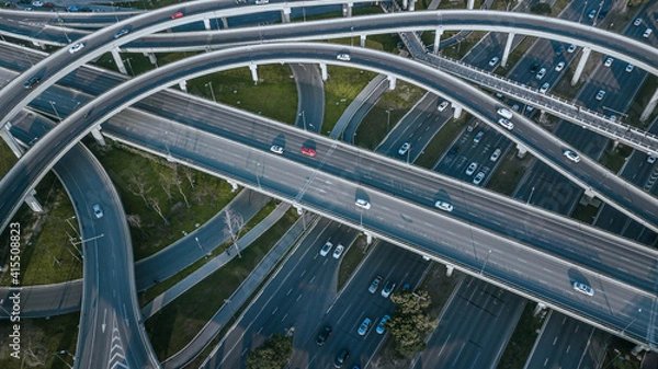 Fototapeta Top up aerial drone view of elevated road and traffic junctions in Chinese metropolis city Chengdu during sunny day. Modern construction design of traffic ways to avoid traffic jams. Few vehicles.
