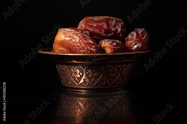 Fototapeta Ramadan concept with dried of dates on black background.