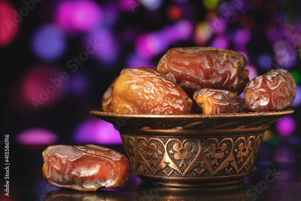Fototapeta Ramadan concept with dried of dates on black background.