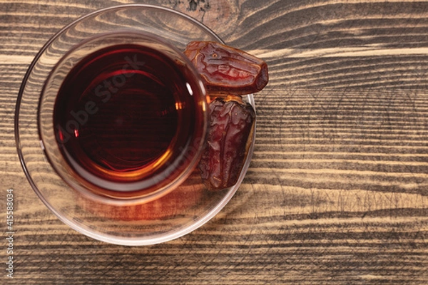Fototapeta A cup of tea and dried dates. Top view