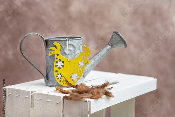 Fototapeta Easter decorations watering can and feathers on the wooden box. Spring came. Easter time