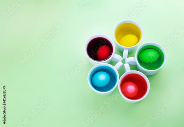 Fototapeta Close up of easter eggs dye process against green background. Image with copy space