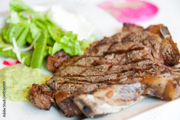 Obraz Steak with marks  on a white plate with some sallad