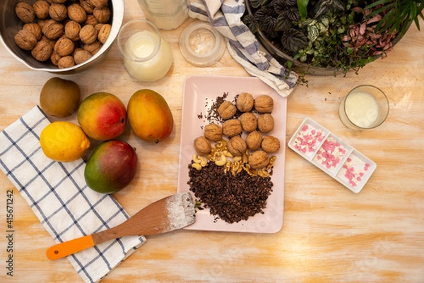 Fototapeta Healthy Food, Mango, Walnuts, Choclate, Chocolate Nips, on wooden background