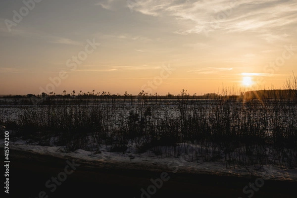 Fototapeta zachód słońca zimą na polach
