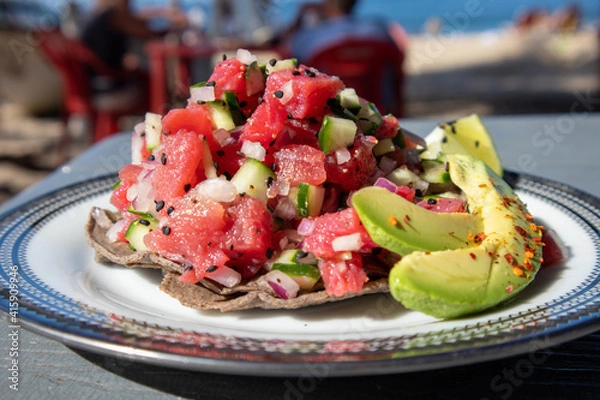 Fototapeta Tuna Ceviche Tostada served with avocado and lime on the beach in Mexico