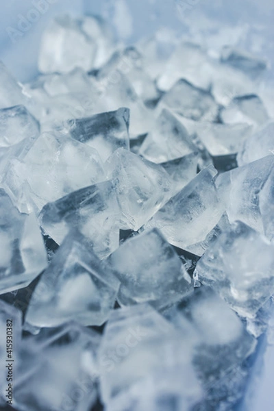 Fototapeta close-up of ice cubes in freezer tray with cold blue tones