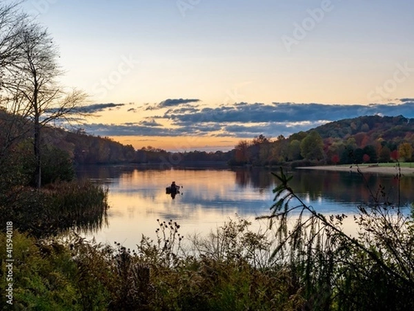 Obraz Keystone Lake in Keystone State Park in West Moreland County in the Laurel Highlands of Pennsylvania in the fall right before sunset with the fall foliage and trees reflecting in the water.