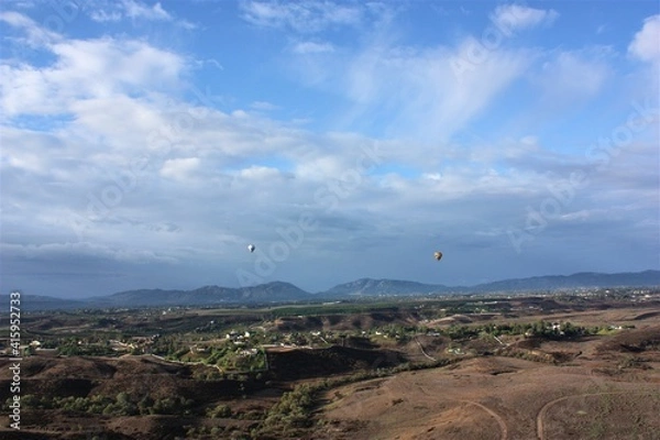 Fototapeta Colorful hot air balloon flying on blue sky background at Temecula in California. aerial view - 気球 カリフォルニア テメキュラ