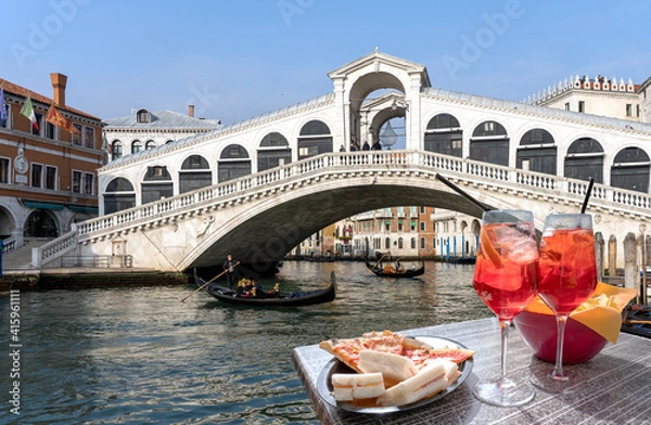 Fototapeta Spritz for two with sandwiches and snacks overlooking the Rialto Bridge in Venice