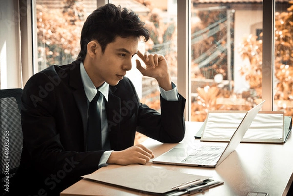 Obraz Smart asian businessman working with laptop at office.