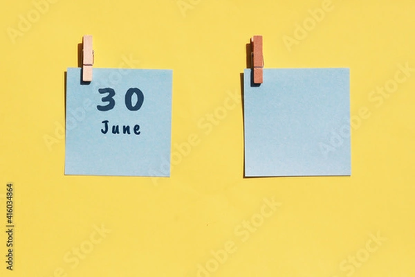 Fototapeta June 30st . Day of 30 month, calendar date. Two blue sheets for writing on a yellow background. Top view, copy space. Summer month, day of the year concept
