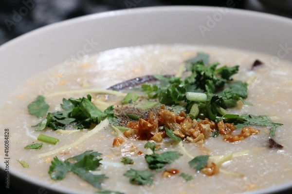 Fototapeta Rice porridge with mince pork and vegetables mixing with the egg