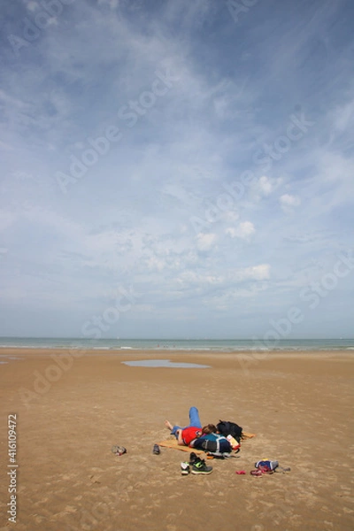 Fototapeta jeune femme allongée seule sur une immense plage