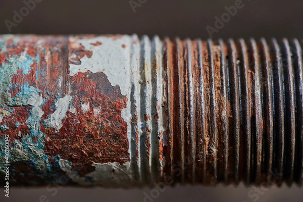 Fototapeta plumbing old rusty water pipe with remnants of sealant and tow on worn threads, peeling paint, selective shallow depth of field