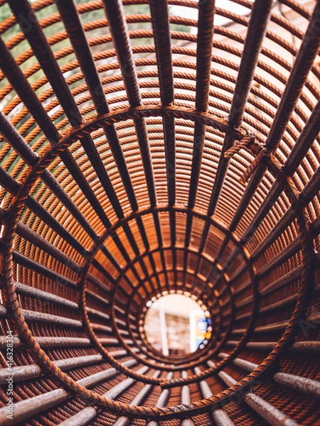 Fototapeta Iron on construction site. Circle Iron Bundle for making reinforcement concrete and plastic orange net. Inside view of rebar for reinforced background net metal red
