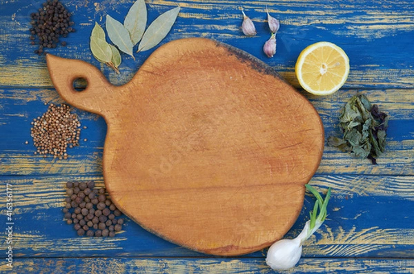 Fototapeta Brown board with free copy space for text decorated with spices and herbs. Top view of spices texture background