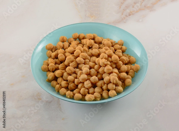 Fototapeta Small bits of caramel pieces for baking in blue ingredient bowl on table