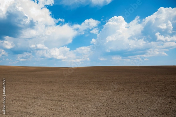 Fototapeta Empty brown soil of field and blue sky for natural background