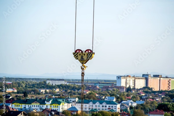 Obraz High-rise construction site. Lifting mechanism of a construction crane. Block of 8 tons with a hook and steel slings .