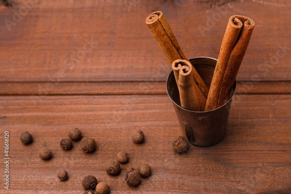 Fototapeta Cinnamon rolls and spice on a wooden surface