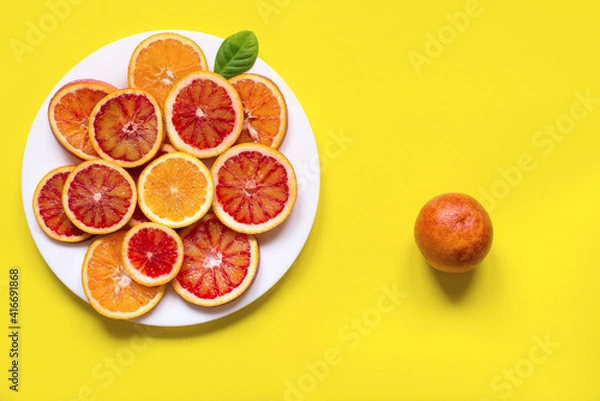 Fototapeta citrus fruit slices on the plate. Top view, yellow background