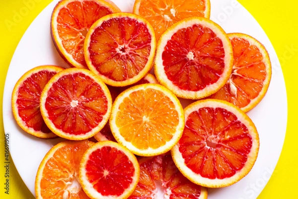 Fototapeta citrus fruit slices on the plate. Top view, yellow background