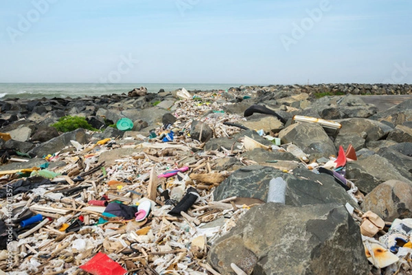 Fototapeta Spilled garbage on the beach near the big city. Empty used dirty plastic bottles and other garbage. Dirty seashore the Tyrrhenian sea. Environmental pollution. Ecological problem.
