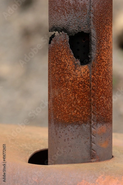 Obraz Old rusty exhaust pipe with a hole in it.