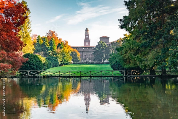 Fototapeta View of the Sforza Castle from Sempione Park (Milan - Italy) in an autumn day with a small lake in the foreground.