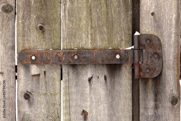 Fototapeta Ancient rusty hinge for the door on the background of an old wooden fence