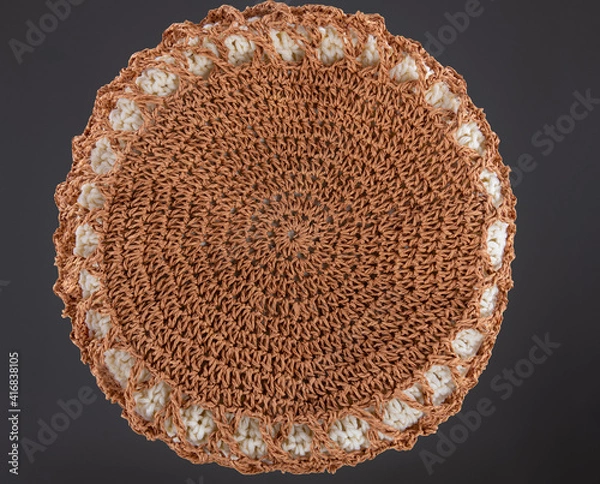 Fototapeta Braided raffia circle. View from above. Handmade beige string bag on grey background. Close-up. Raffia bag. Wicker bag.