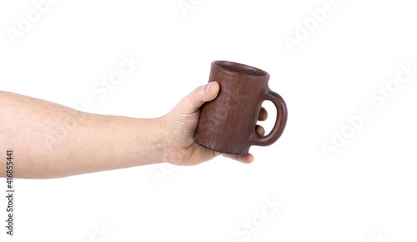 Fototapeta A man's hand with a clay cup isolated on a white background. Copy space. Clay cup. Hand holding a clay cup