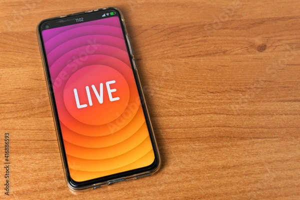 Fototapeta Phone with Live stream logo on table