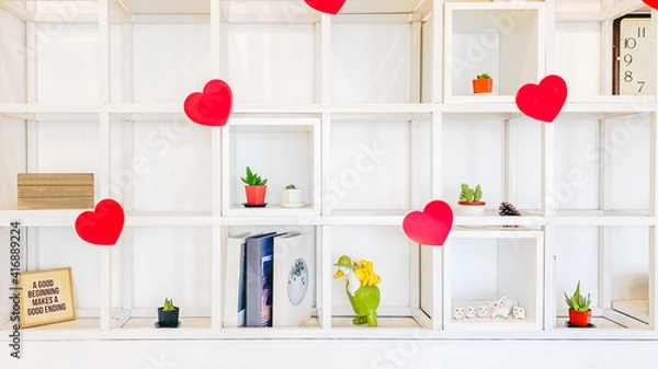 Fototapeta White bookshelf on the wall decorated with red hearts