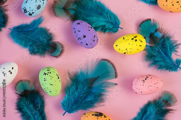 Obraz Colored easter eggs and blue feather on a pink background