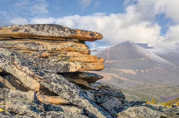 Obraz Slabs of granite rock against the backdrop of mountains and blue sky.