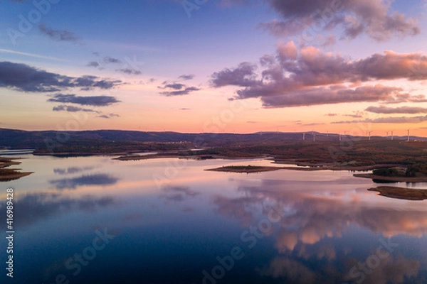 Fototapeta Drone aerial view of a lake reservoir of a dam with perfect reflection on the water of the sunset in Sabugal, Portugal