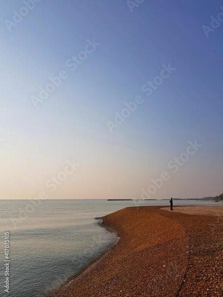 Obraz Landscape sea view with beautiful sunset sky and one man stand on beach.