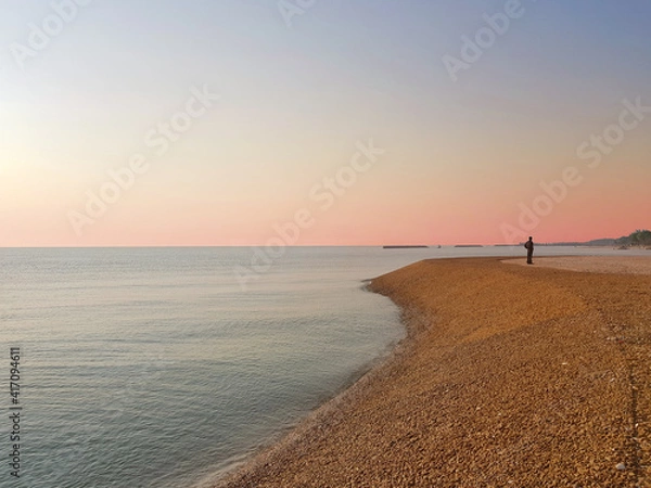 Obraz Landscape sea view with beautiful sunset sky and one man stand on beach.