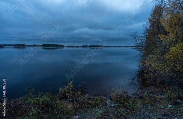 Fototapeta Man made lake basin with boreal forest in autumn