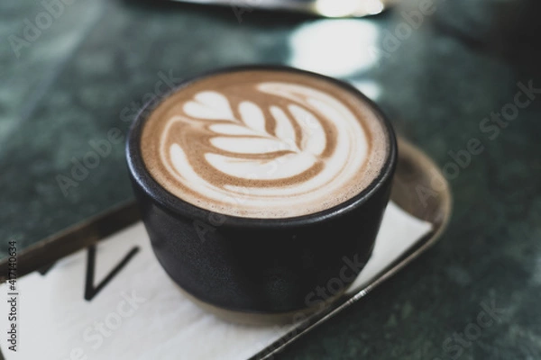 Obraz Black ceramic cup of hot coffee latte foam design art on the tray on green marble table. Barista craft.