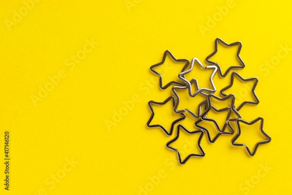 Obraz Heap of shiny metal split key rings for keychains. Chromium plated keychain clasp on yellow background. Flat lay, top view with copy space.